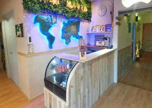 a restaurant with a counter with a world on the wall at GREEN Hostel MADRID GRAN VIA in Madrid