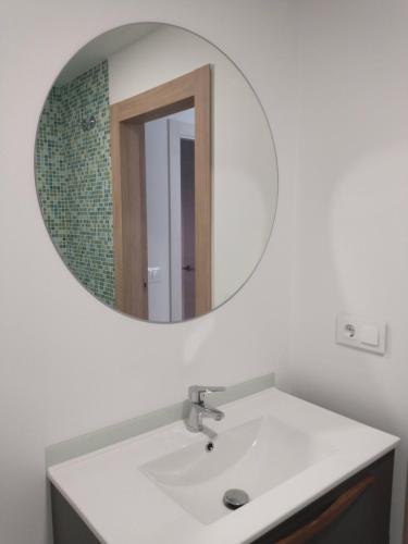 a bathroom with a white sink and a mirror at Modern nieuwbouwappartement aan het strand van de Mar Menor in Santiago de la Ribera in Lo Pagán