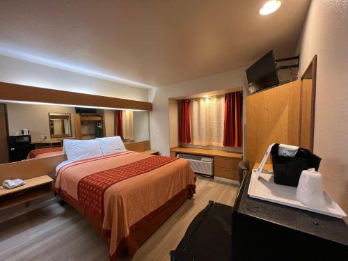 um quarto de hotel com uma cama e uma televisão de ecrã plano em Americas Best Value Inn and Suites Ada em Ada