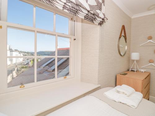sypialnia z łóżkiem i dużym oknem w obiekcie Upper Tremorvah w mieście Dartmouth