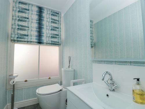 łazienka z toaletą, umywalką i oknem w obiekcie Upper Tremorvah w mieście Dartmouth