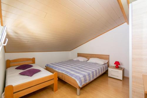 1 dormitorio con 2 camas y techo de madera en Apartments by the sea Mandre, Pag - 205, en Kolan