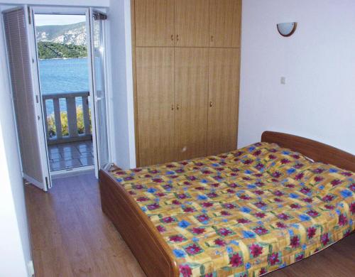 1 dormitorio con 1 cama y puerta a un balcón en Apartments by the sea Kneza, Korcula - 167, en Račišće