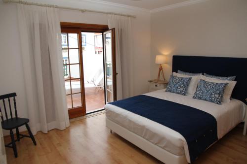 a bedroom with a bed and a sliding glass door at PIER HOUSES by Nature Bliss in Vila Nova de Milfontes