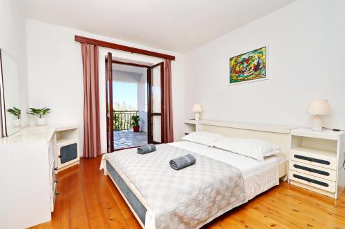um quarto branco com uma cama e uma janela em Apartments by the sea Brna, Korcula - 173 em Smokvica