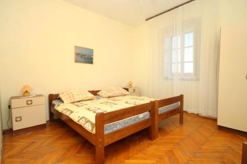 a bedroom with a wooden bed and a window at Apartments with parking space Lumbarda, Korcula - 179 in Lumbarda