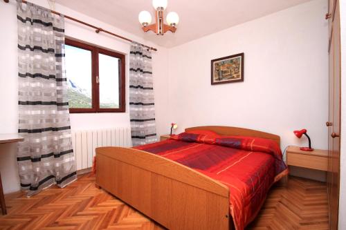 sypialnia z łóżkiem z czerwonym kocem w obiekcie Apartments by the sea Korcula - 157 w Korčuli