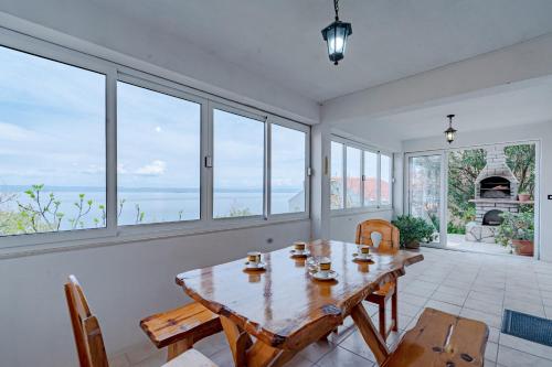 a dining room with a table and chairs and windows at Apartments by the sea Prigradica, Korcula - 248 in Blato