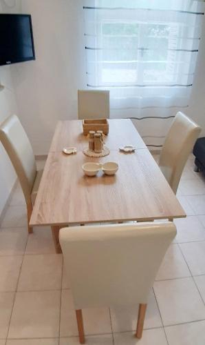 a wooden table with chairs and a laptop on it at Apartment Zavalatica 189b in Zavalatica