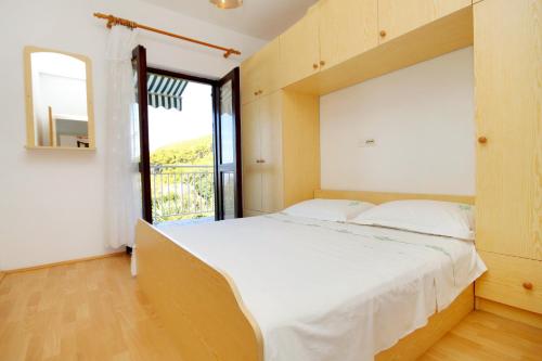 a bedroom with a large bed and a window at Apartments with a parking space Prizba, Korcula - 219 in Prizba