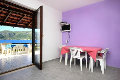 ein Esszimmer mit einem roten Tisch und Stühlen in der Unterkunft Apartments by the sea Tri Zala, Korcula - 174 in Korčula