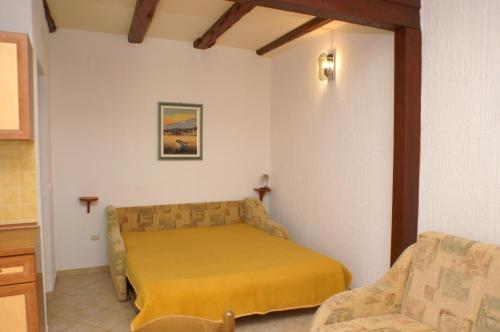 - une chambre avec un lit et une chaise dans l'établissement Apartments with a parking space Povljana, Pag - 233, à Povljana