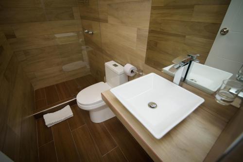 a bathroom with a white sink and a toilet at HOTEL PIEDRA SANTA - Moquegua in Moquegua