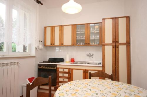 eine Küche mit einem Tisch, einer Spüle und Schränken in der Unterkunft Apartments with a parking space Povljana, Pag - 226 in Povljana