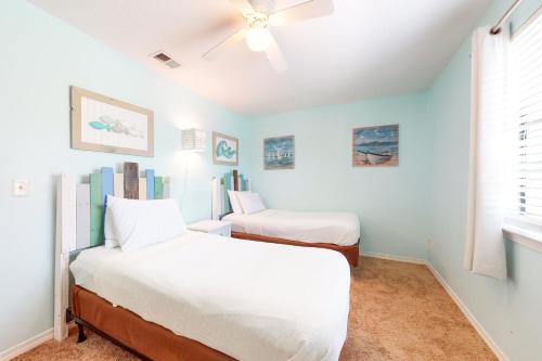 a bedroom with two beds and a ceiling fan at Gulf Highlands - 173 Damon Circle in Panama City Beach