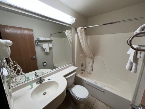 uma casa de banho com um lavatório, um WC e um espelho. em Americas Best Value Inn and Suites Ada em Ada