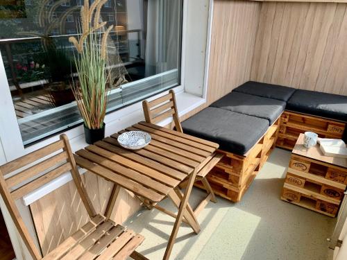 un pequeño porche con banco, mesa y silla en Haus Dünenbake - Apartment 23, en Sankt Peter-Ording