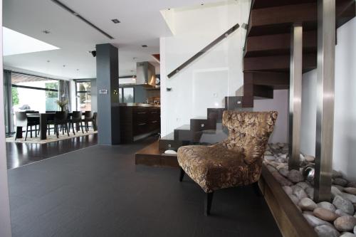 a living room with a chair and a staircase at Villa Hanan Sarajevo in Sarajevo
