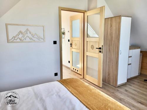- une chambre avec un lit et une porte ouverte dans l'établissement Apartament Nad Zaporą, à Szlembark