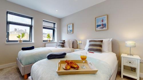 a bedroom with two beds with a tray of food and drinks at Chatham Serviced Apartments by Hosty Lets in Chatham