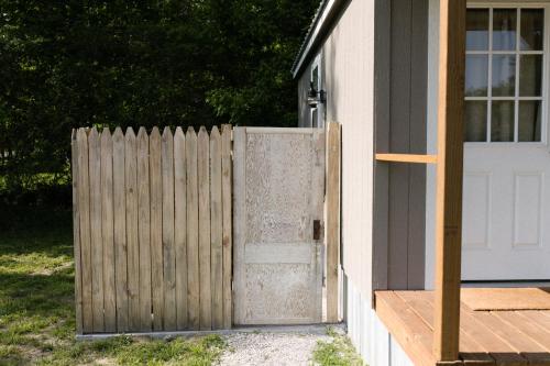 a wooden fence with a door next to a house at The Outpost in Grand Rivers