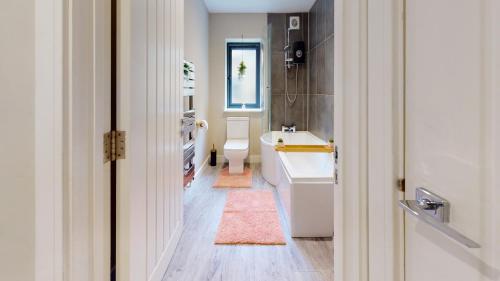 a bathroom with a sink and a tub and a toilet at Chatham Serviced Apartments by Hosty Lets in Chatham