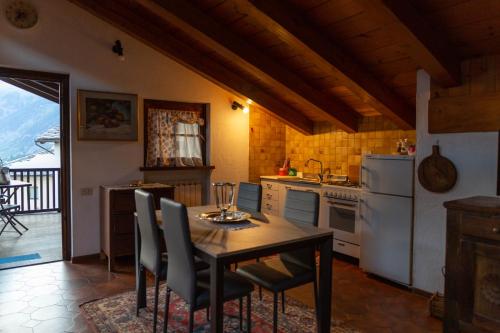 cocina con mesa, sillas y nevera en Maison Mont-Blanc, en La Salle