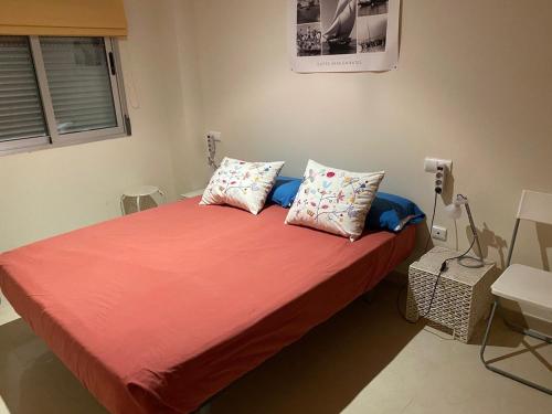 オロペサ・デル・マールにあるApartamento Marina D'Or 1ª linea de playaのベッドルーム1室(赤いシーツと枕のベッド1台付)