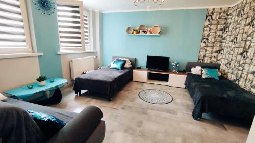 un salon avec un canapé et un lit dans l'établissement Apartament 25, à Płock