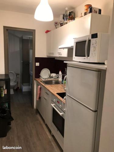 uma cozinha com um micro-ondas e um fogão forno superior em Appartement 4 couchages - Port ciotat em La Ciotat