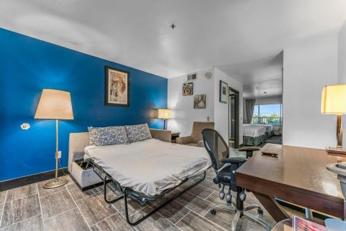 a room with a bed and a desk and a table at METRO TEMPE APARTMENTS studio w two king beds in Tempe