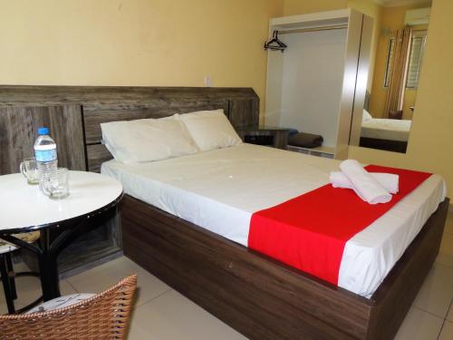 1 dormitorio con 1 cama con manta roja y mesa en Hotel São Judas - Próximo a Expo São Paulo, en São Paulo
