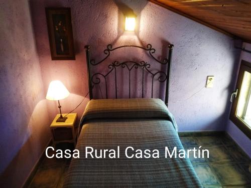 a bedroom with a bed with a metal headboard and a lamp at Casa Rural Casa Martin in Cueva de Ágreda