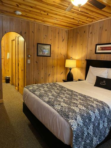 a bedroom with a bed in a room with wooden walls at Harney Peak Inn in Hill City