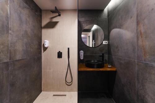 a bathroom with a shower with a sink and a mirror at The White Tree in Pristina