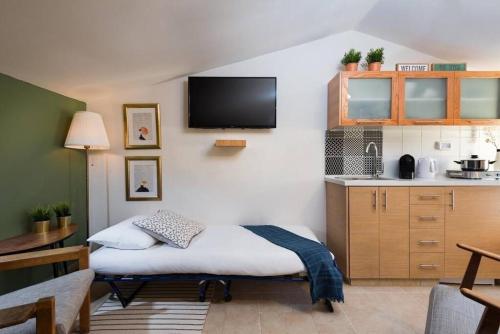 a small room with a bed and a kitchen at Ovadia Somech #4 in Jerusalem