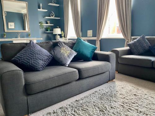 a living room with a couch with pillows on it at Beautiful City Centre Apartment Close to Minster in York