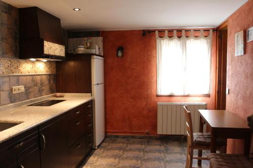 uma cozinha com um lavatório, uma mesa e uma janela em Casa Rural Casa Martin em Cueva de Ágreda