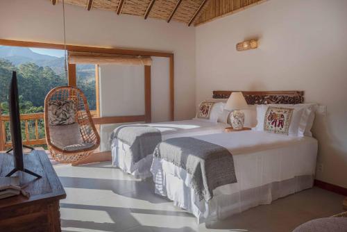 a bedroom with two beds and a large window at Embaúba Boutique Hotel in Teresópolis