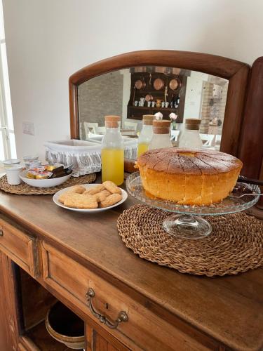 a table with a cake and cookies and orange juice at Il Casale dei Calanchi in Aliano