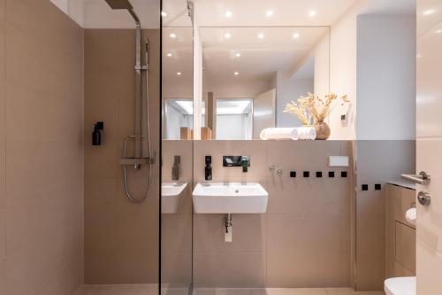 bagno con doccia, lavandino e specchio di Spacious apartment in Hemholtzkiez Prenzlauer Berg for 8 People a Berlino