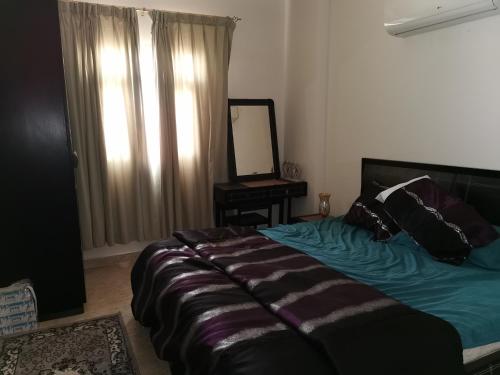 1 dormitorio con 1 cama con espejo. en Seeb Lux Apartment, en Mascate