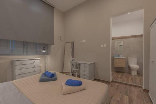 a bedroom with a large bed with blue pillows on it at Sliema - 2 mins from the Beach in Sliema