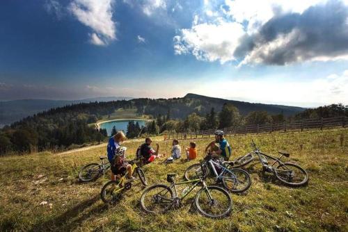 grupa ludzi z rowerami na wzgórzu w obiekcie Place Royale pour 10 à 12 personnes à 30 mèt des pistes de Ski et Vtt w mieście Métabief