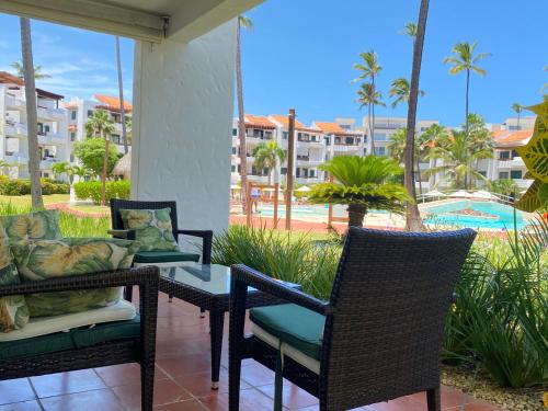 a patio with chairs and a table and a pool at Stanza Mare Beach Front in Punta Cana