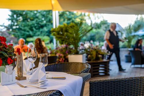 a table with a white table cloth and wine glasses at Hotel Blinkfüer in Dierhagen