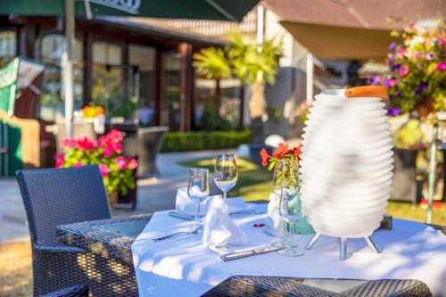 a table with a white vase and wine glasses on it at Hotel Blinkfüer in Dierhagen