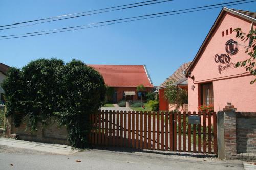 a wooden fence in front of a pink building at Ottó Panzió Villány in Villány
