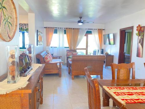 a living room with wooden tables and chairs at Stanza Mare Beach Front in Punta Cana