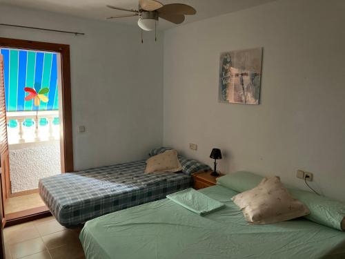 2 camas en una habitación con ventana en Duplex familiar, en Puerto de Mazarrón